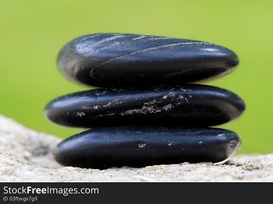 Three black stones with green background. Three black stones with green background