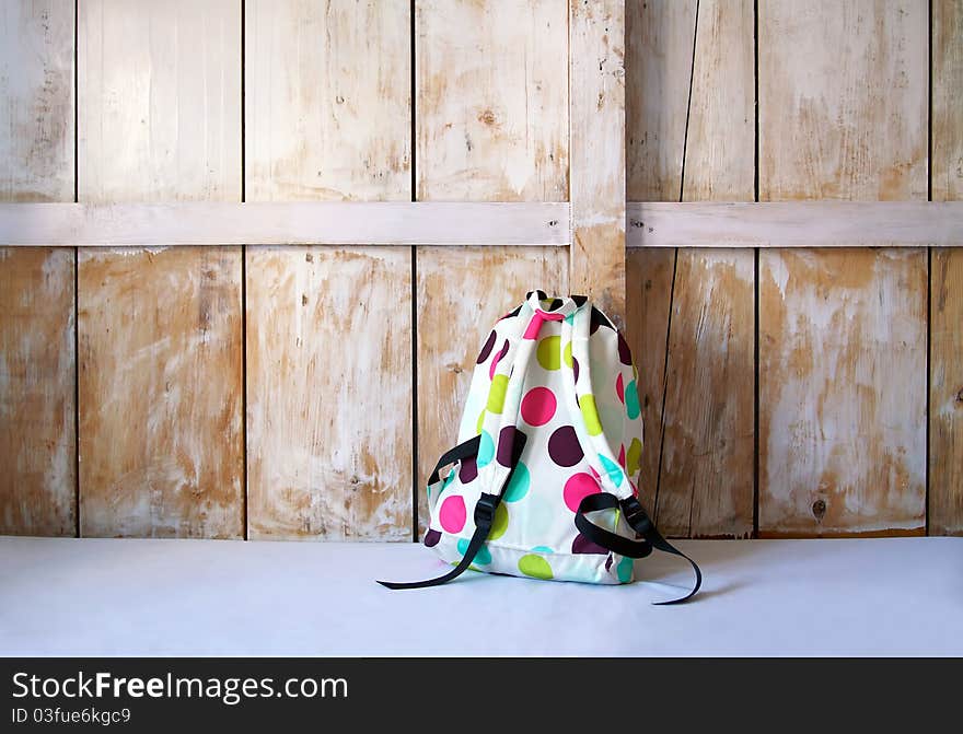 Colored backpack on wood background