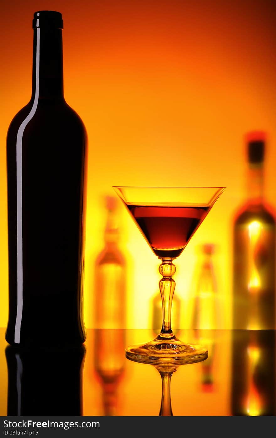 Dark bottle and glass on a background with the shadows of bottles