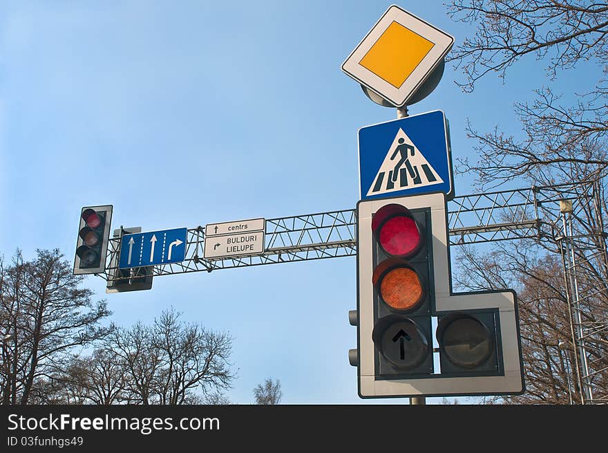 Traffic lights and road signs against sky