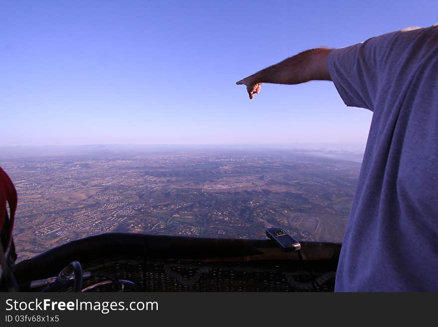 Man Points Towards The Horizon In Hot Air Balloon