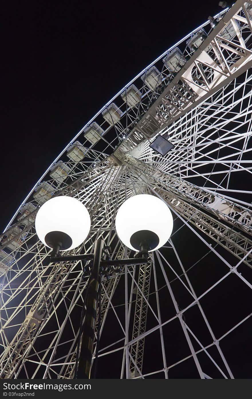 A giant ferris wheel, took from bottom-up, by night, with black background. A giant ferris wheel, took from bottom-up, by night, with black background