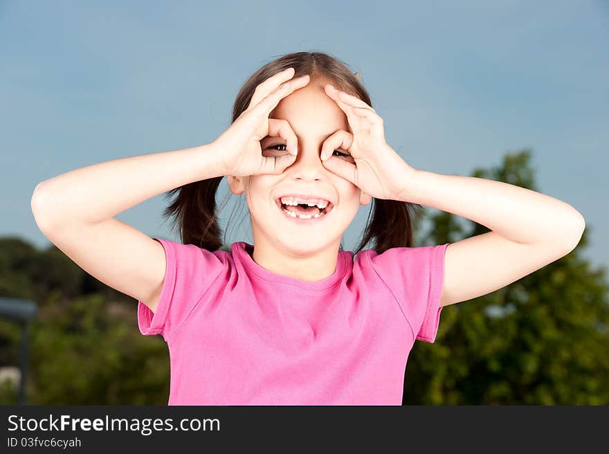 Little girl simulating binoculars with her hands