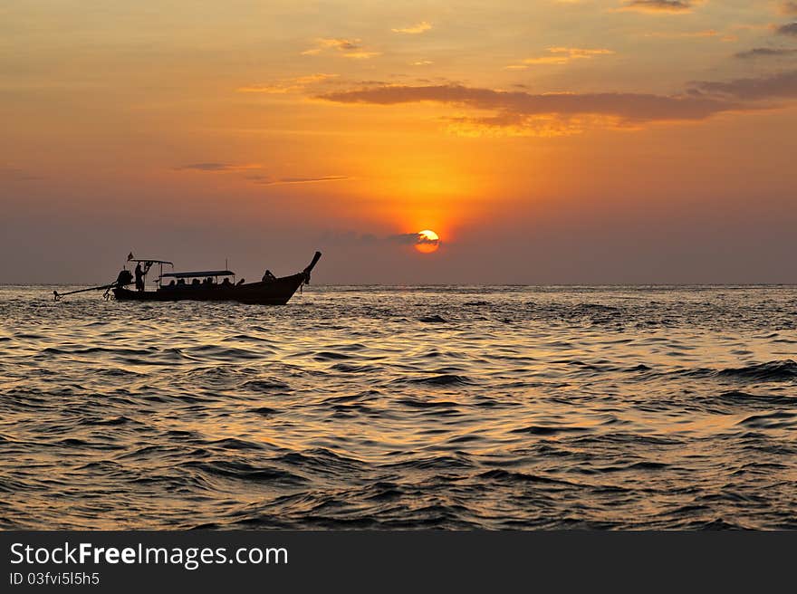 Long tail boat on andaman's sea during the sunset