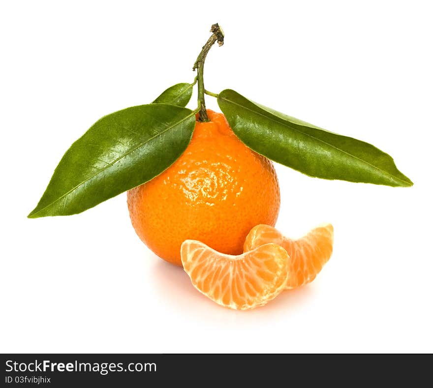 Ripe tangerine with segments and with green leaves on a white background