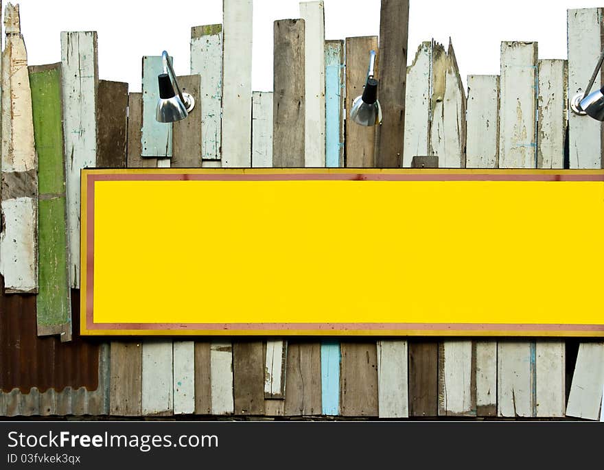 Yellow signboard on old wood wall with sport light for text in