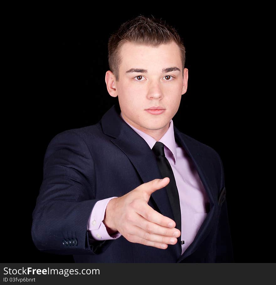 A photograph of a young executive with his hand out to shake anothers. A photograph of a young executive with his hand out to shake anothers.