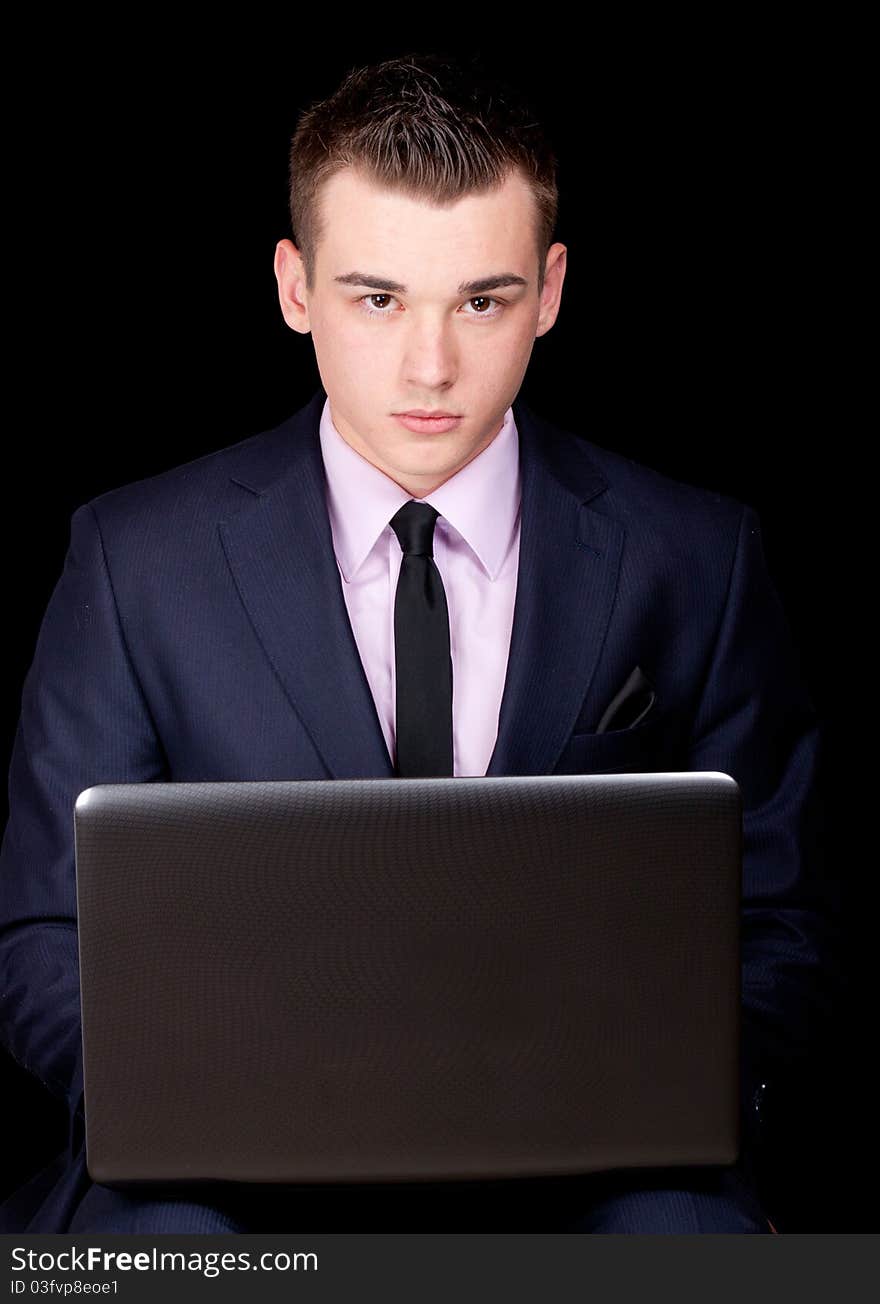 A photograph of a young executive sitting down with his laptop. A photograph of a young executive sitting down with his laptop.