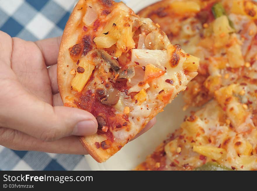 Hand taking single slice of Italian pizza. Hand taking single slice of Italian pizza.