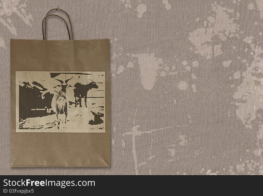 Paper bag hanging on spotted linen structure. Label with self-created design. Paper bag hanging on spotted linen structure. Label with self-created design