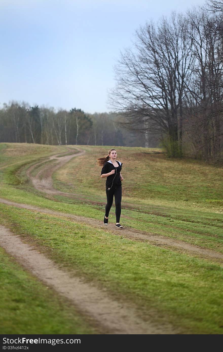 A young girl jogging in a park. A young girl jogging in a park