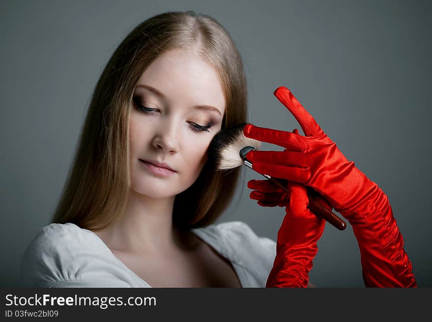 Image of girl in gloves with the professional makeup brush in her hands. Image of girl in gloves with the professional makeup brush in her hands.