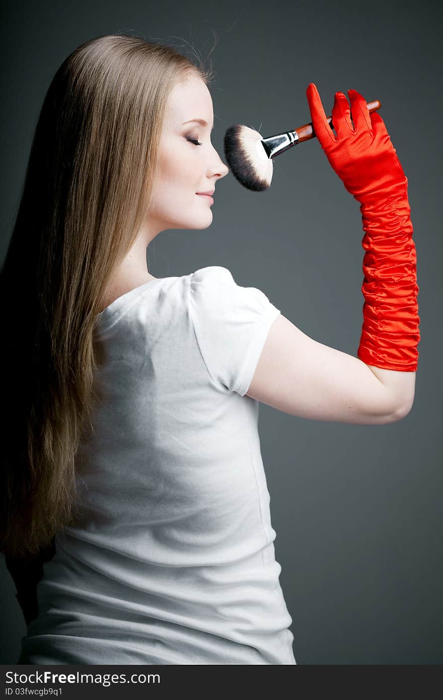 Image of girl in gloves with the professional makeup brush in her hands. Image of girl in gloves with the professional makeup brush in her hands.