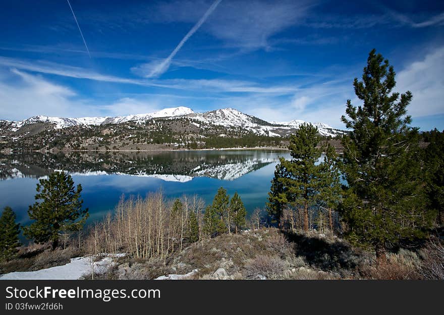 The serene reflection of June Lake stretching across a beautiful panorama. The serene reflection of June Lake stretching across a beautiful panorama.