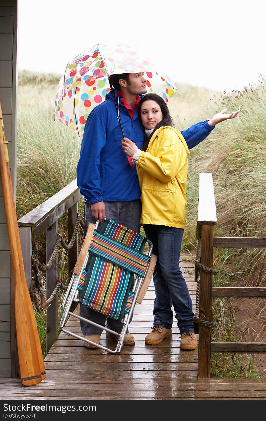 Young Couple On Beach With Umbrella