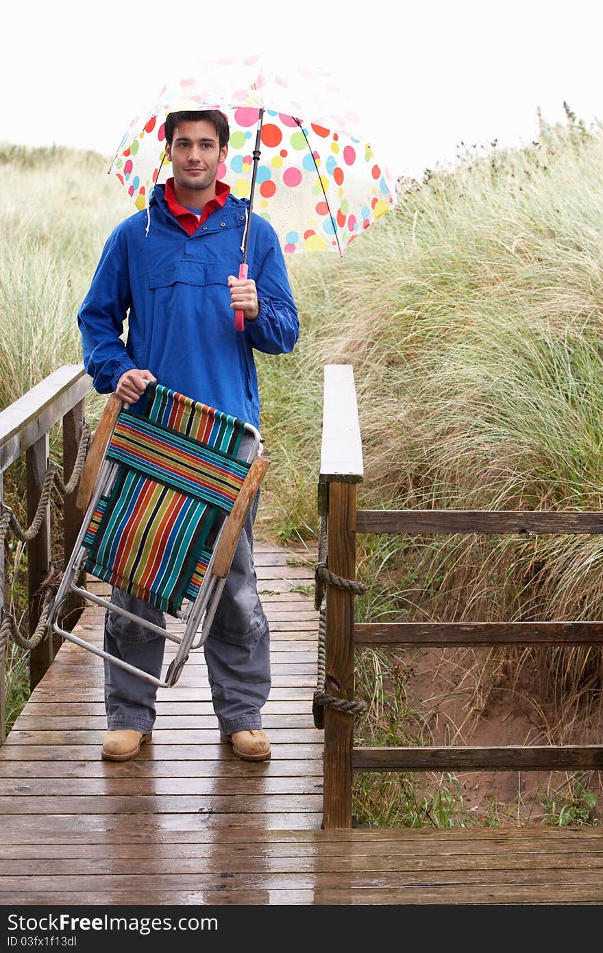 Young man with umbrella smiling