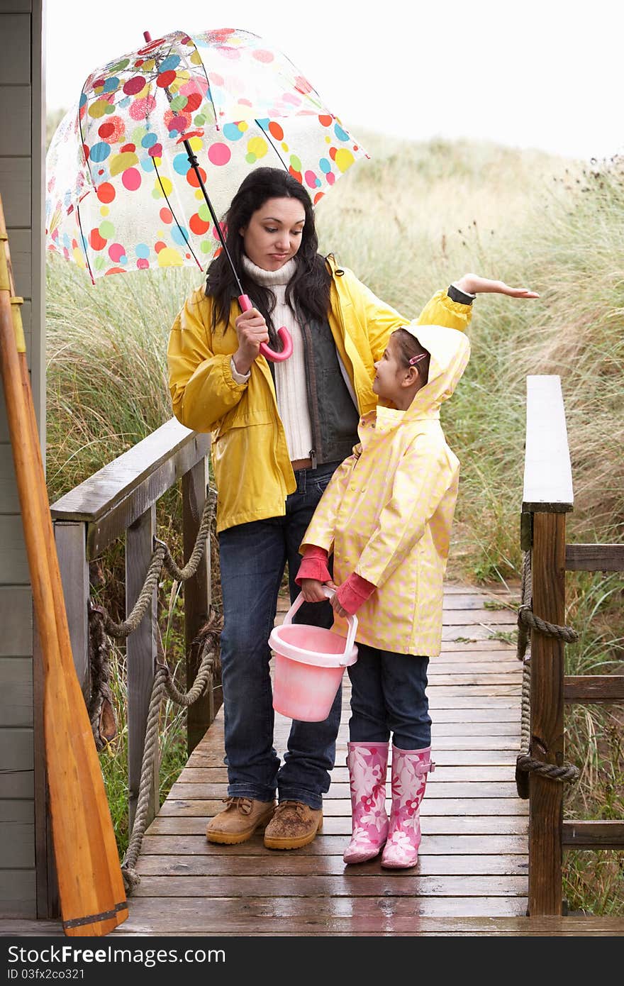 Mother and daughter with umbrella looking sad