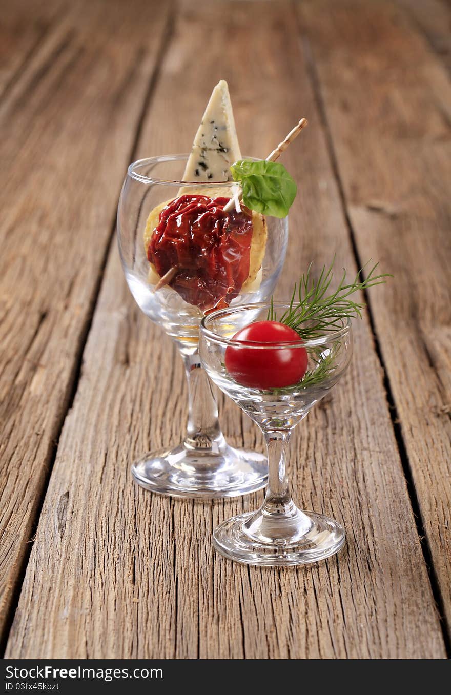 Dried tomato and slice of blue cheese in wine glass. Dried tomato and slice of blue cheese in wine glass