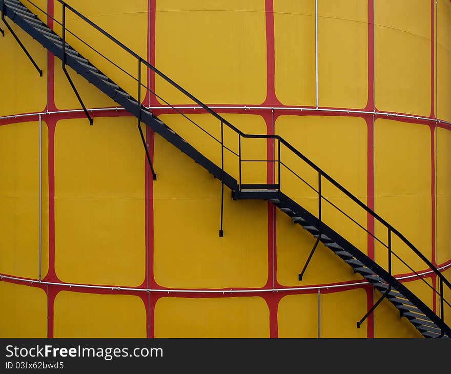 Closeup of yellow cistern whit black metal steps