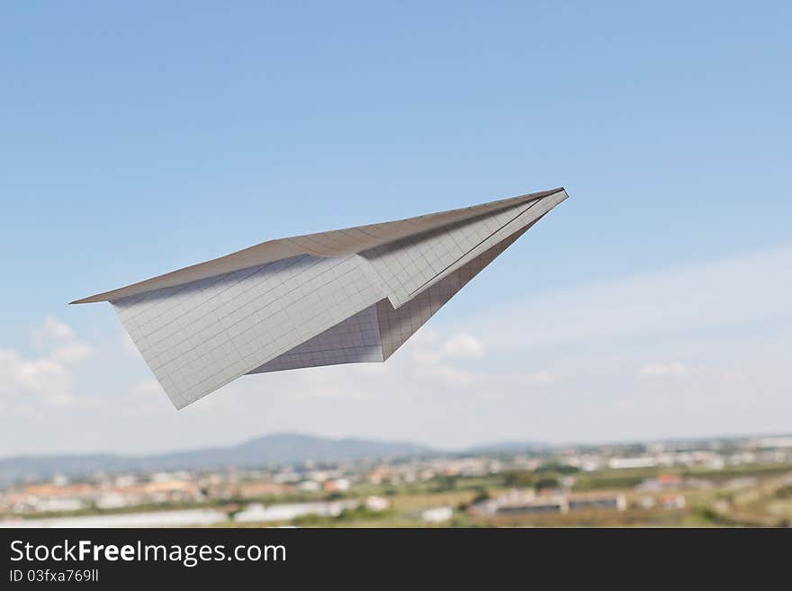 Paper airplane against the blue sky with a beautiful horizon