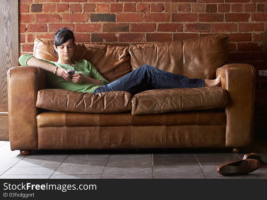 Young woman with phone on sofa