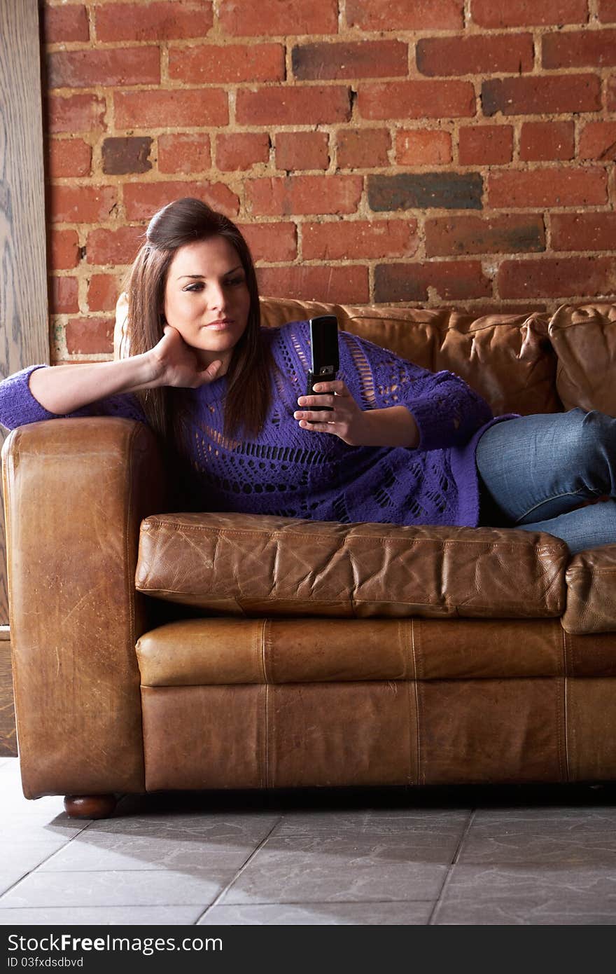 Young woman with phone on sofa