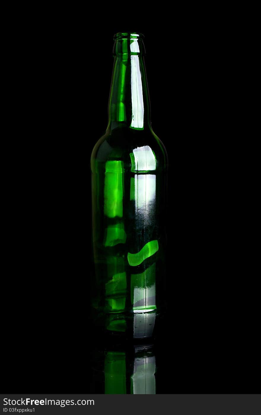 Green glass bottle isolated on a black background