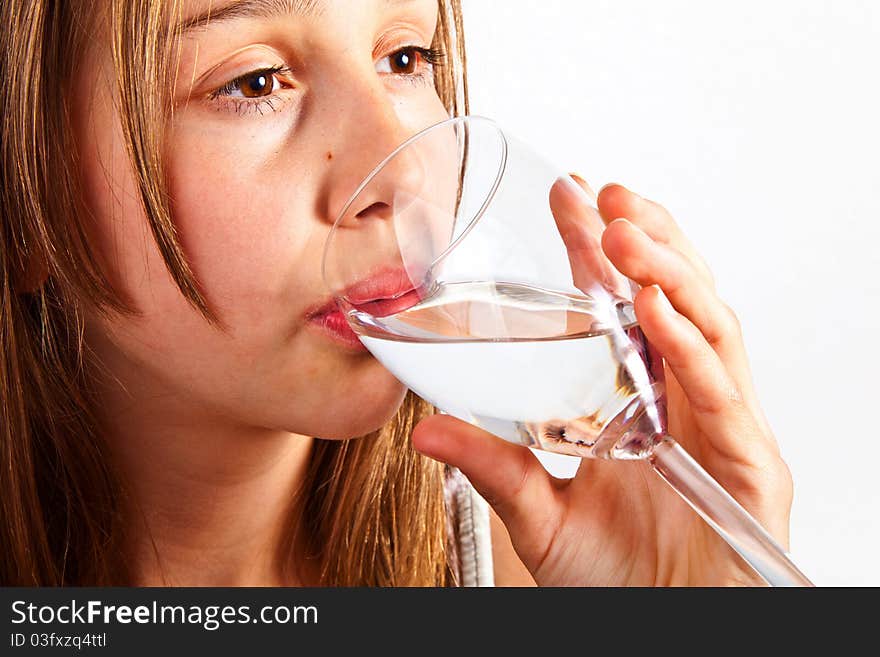 Portrait of cute young teenage girl drinking out of a glass. Portrait of cute young teenage girl drinking out of a glass