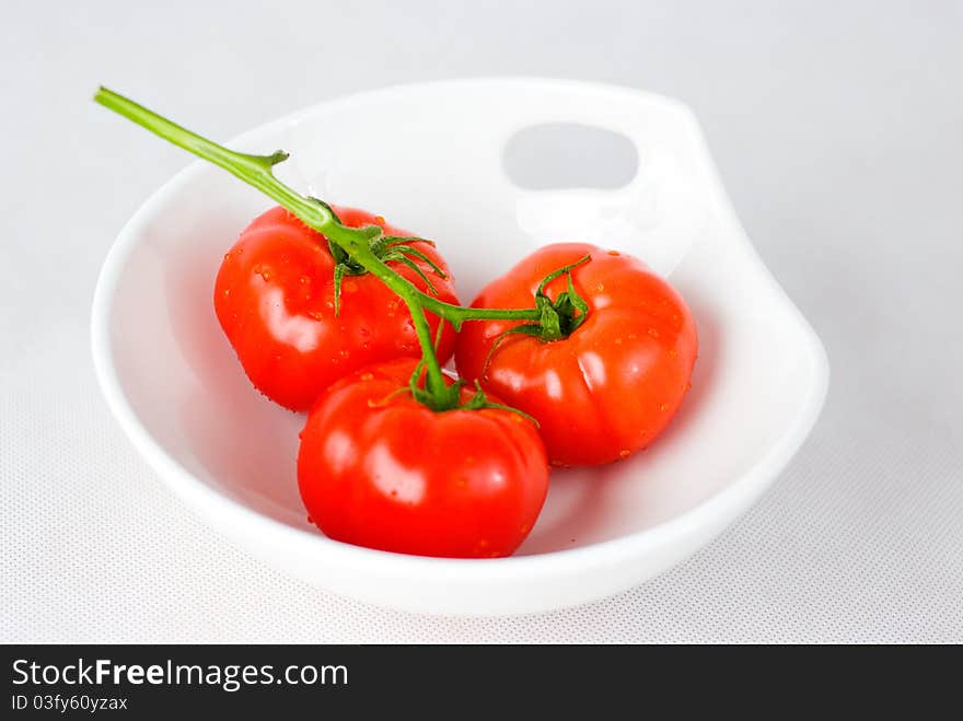 Red fresh tomatoes in the white bowl. Red fresh tomatoes in the white bowl