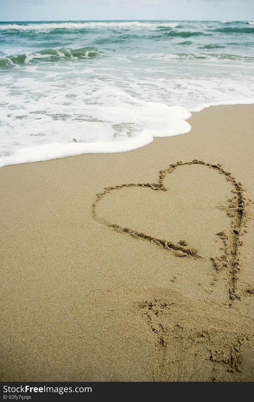 Heart drawing on the sand beach