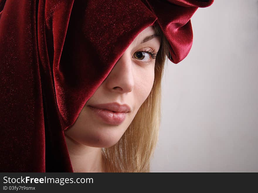 Portrait of the girl of the blonde with a fabric. Studio.