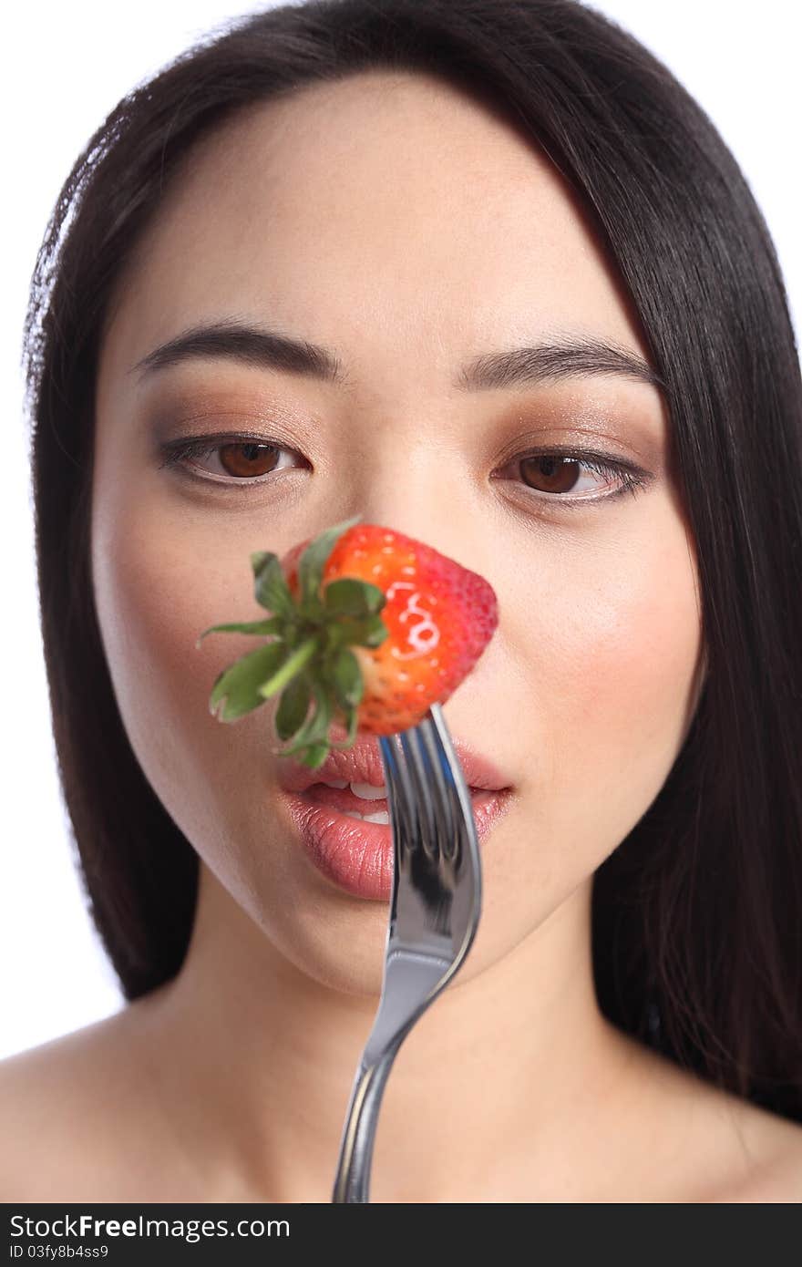 Going cross eyed, an exotic and beautiful young oriental girl, with long black hair ready to eat a fresh strawberry fruit on a fork. Going cross eyed, an exotic and beautiful young oriental girl, with long black hair ready to eat a fresh strawberry fruit on a fork.