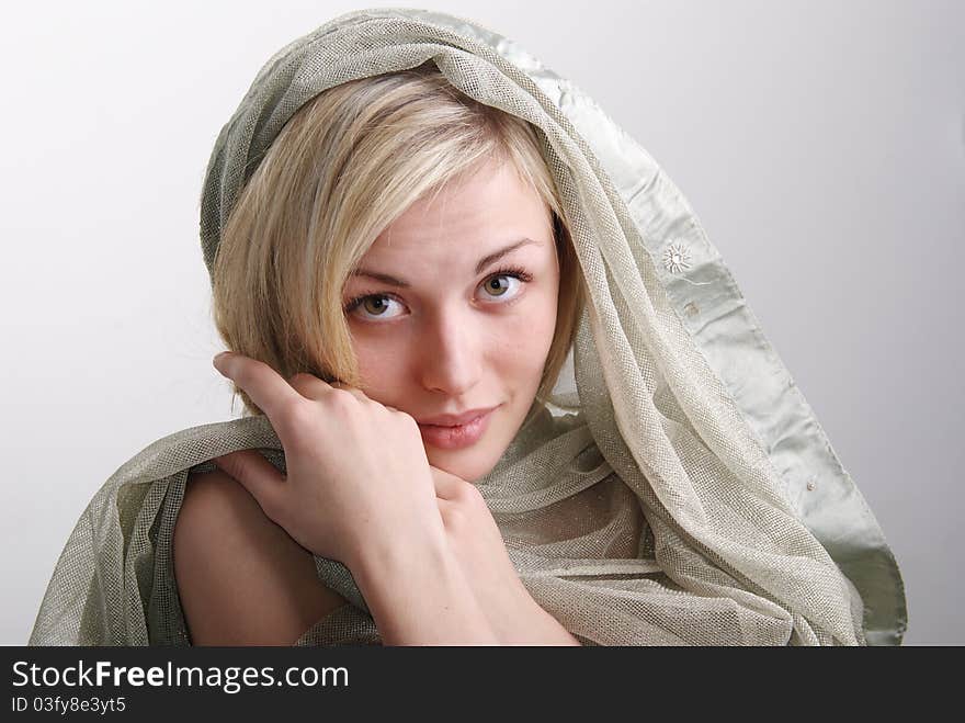 Portrait of the girl of the blonde with a fabric. Studio.