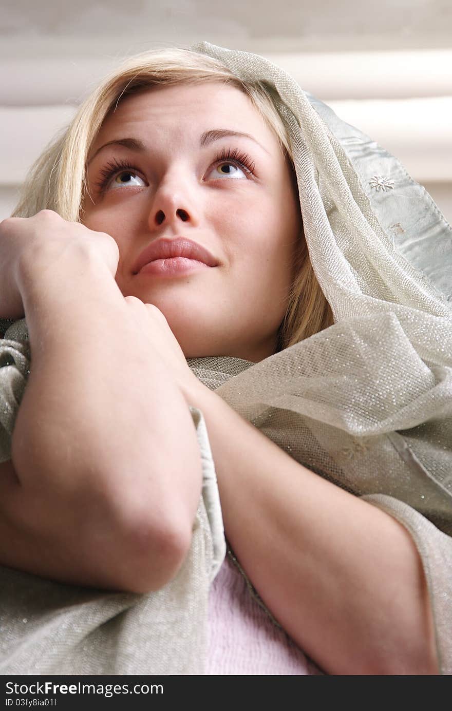 Portrait of the girl of the blonde with a fabric. Studio.