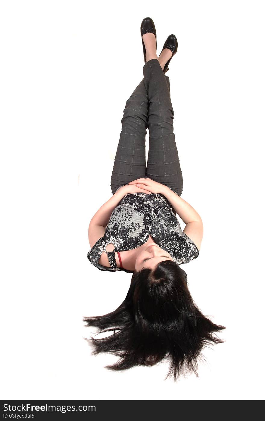 A young pretty woman lying on the floor with her legs up in the air and 
her black hair on the floor, in slakes and blouse, for white background. A young pretty woman lying on the floor with her legs up in the air and 
her black hair on the floor, in slakes and blouse, for white background.