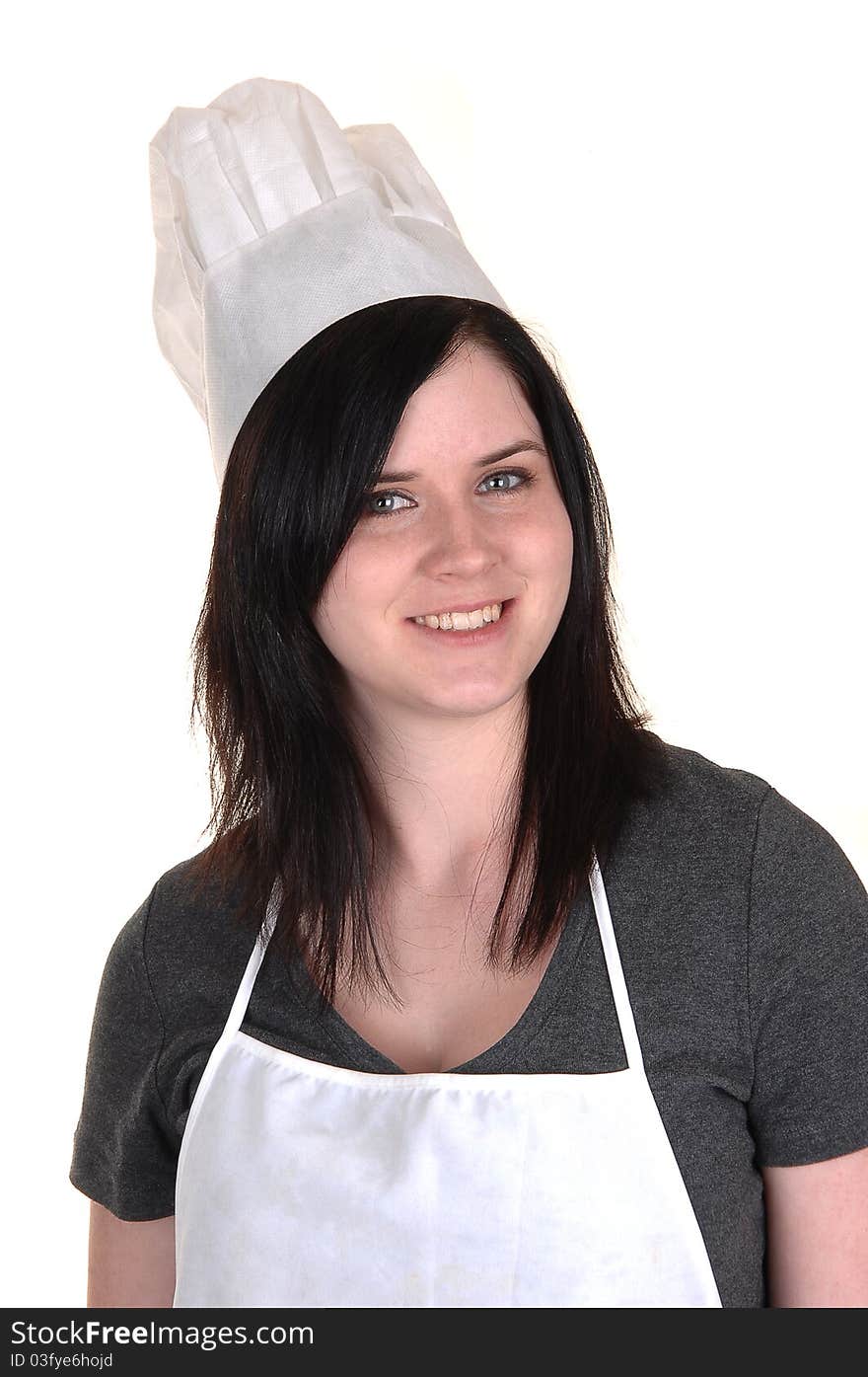 A lovely portrait of a young woman with an apron and cooking hat, smiling into the camera for white background. A lovely portrait of a young woman with an apron and cooking hat, smiling into the camera for white background.