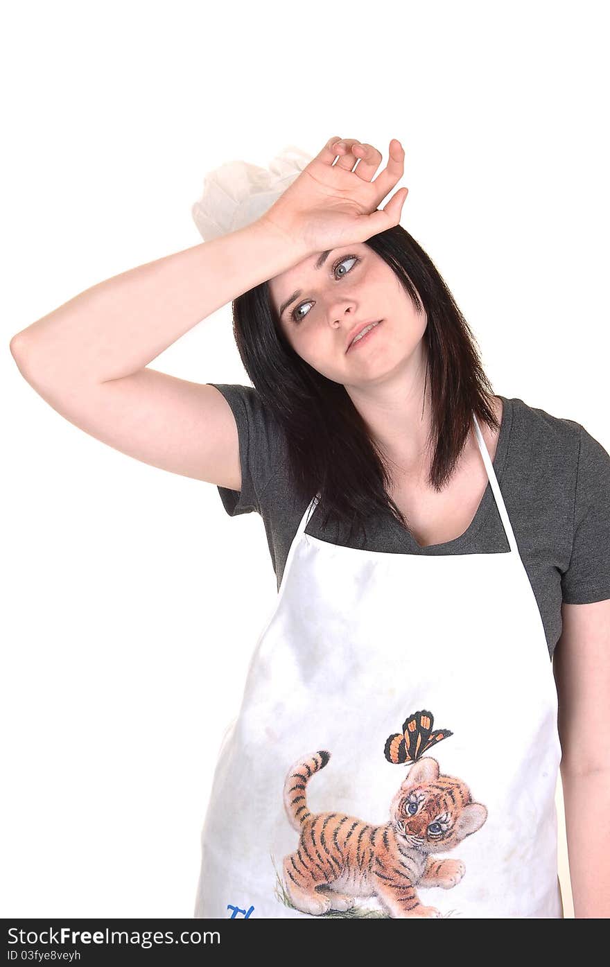 The picture of an exhausted young woman with an apron and a cooking hat, wishing the sweat from her forehead, on white background. The picture of an exhausted young woman with an apron and a cooking hat, wishing the sweat from her forehead, on white background.