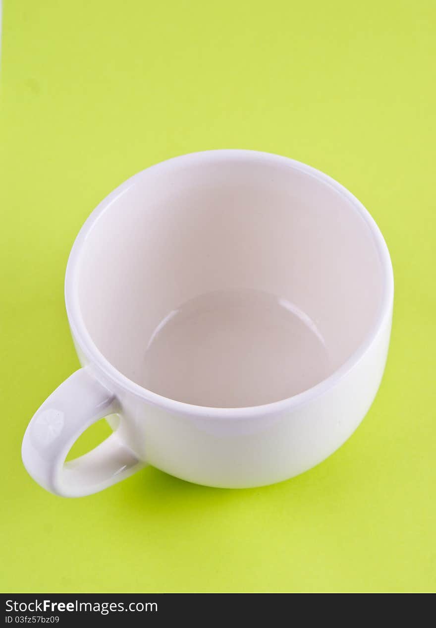 White empty cup. On a green background