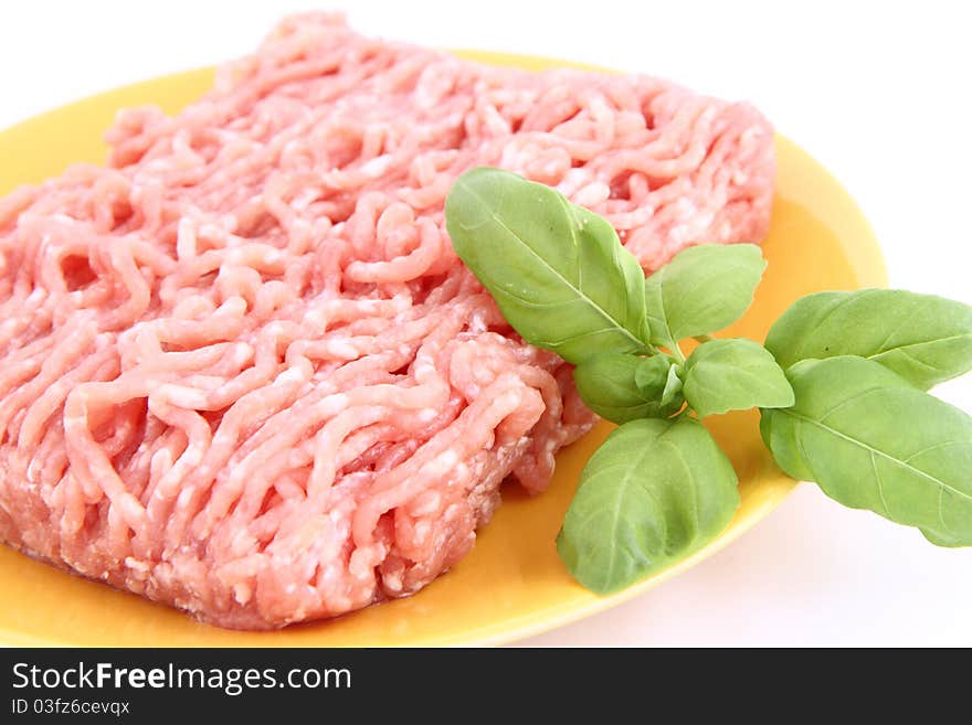 Raw minced meat on a plate decorated with basil