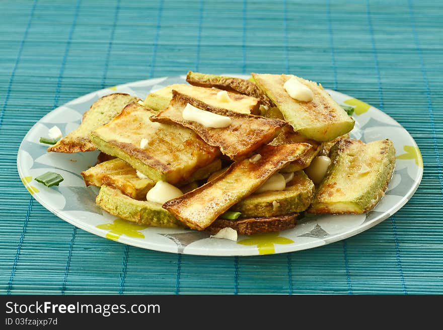 Fried zucchini with garlic closeup on a plate