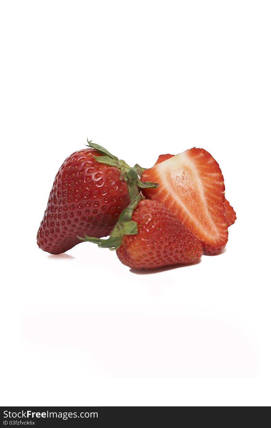 A group of sliced and unsliced strawberries isolated on a white background.