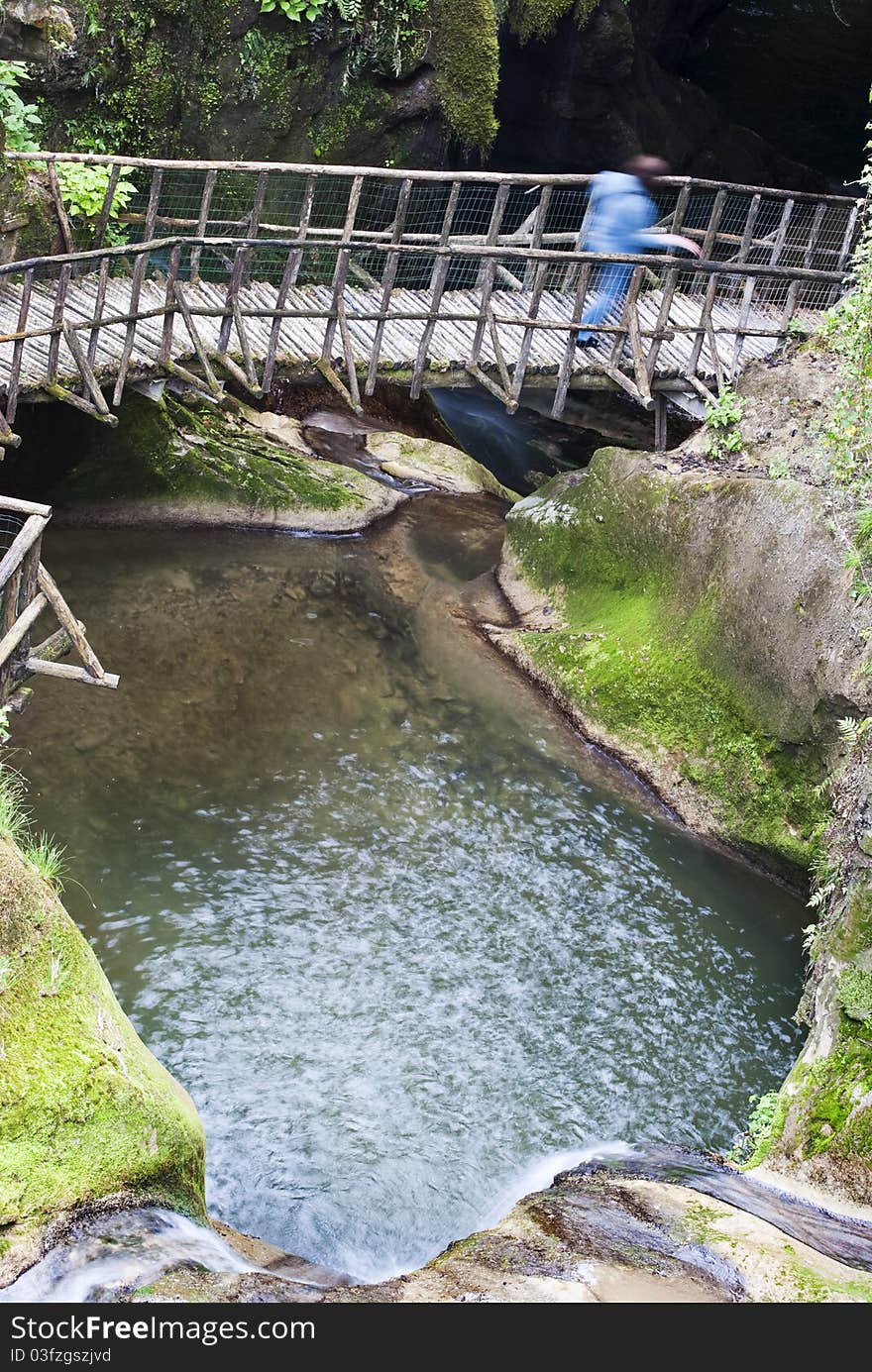 An amazing and scenic grotto whit a person walking on a wooden bridge,long exposure. An amazing and scenic grotto whit a person walking on a wooden bridge,long exposure