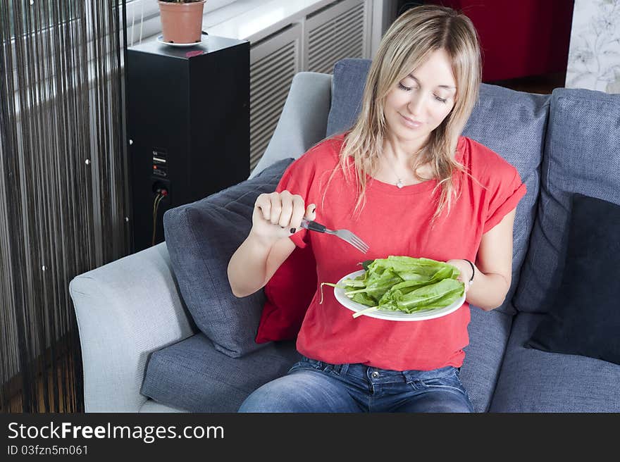 Beautiful blond woman eating green leaves as a healthy meal. Beautiful blond woman eating green leaves as a healthy meal