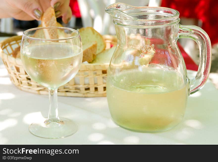 White wine in a glass and a bowl, bread on background. White wine in a glass and a bowl, bread on background