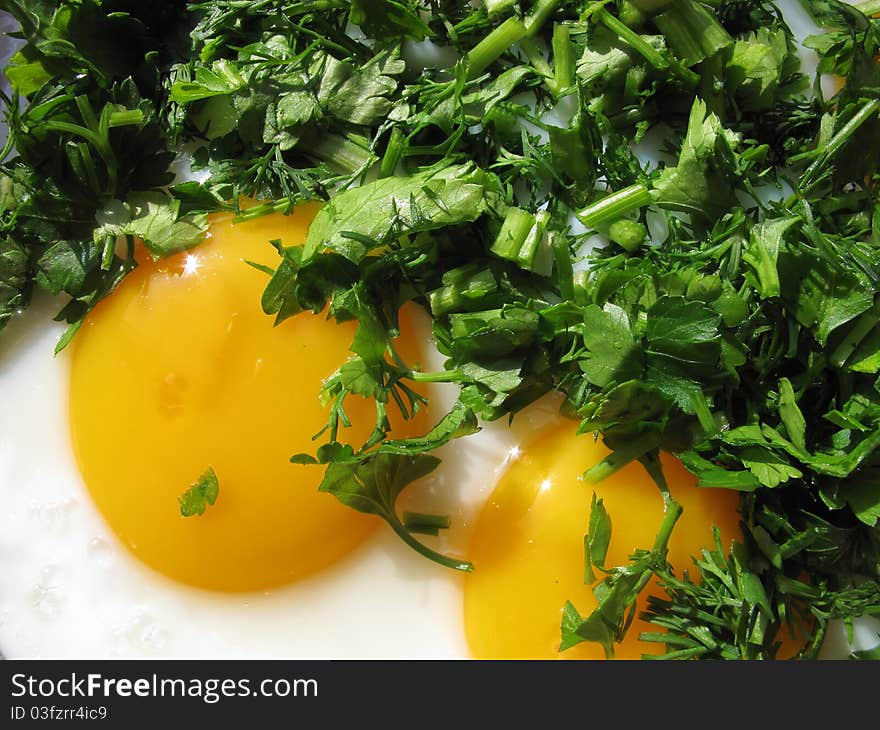 Fried eggs with greenery on a frying pan. Fried eggs with greenery on a frying pan.