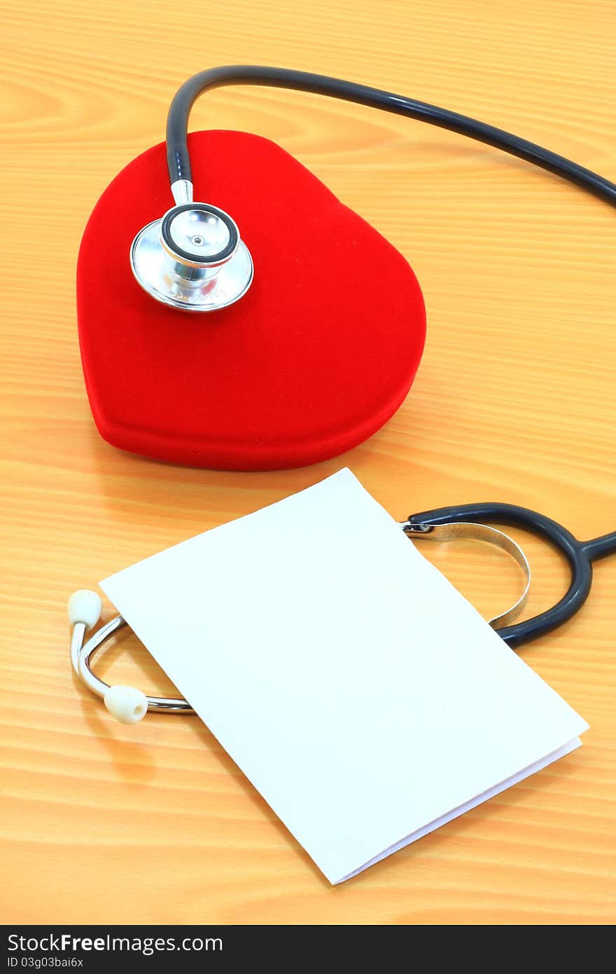 Paper note,stethoscope and red heart on wood background. Paper note,stethoscope and red heart on wood background