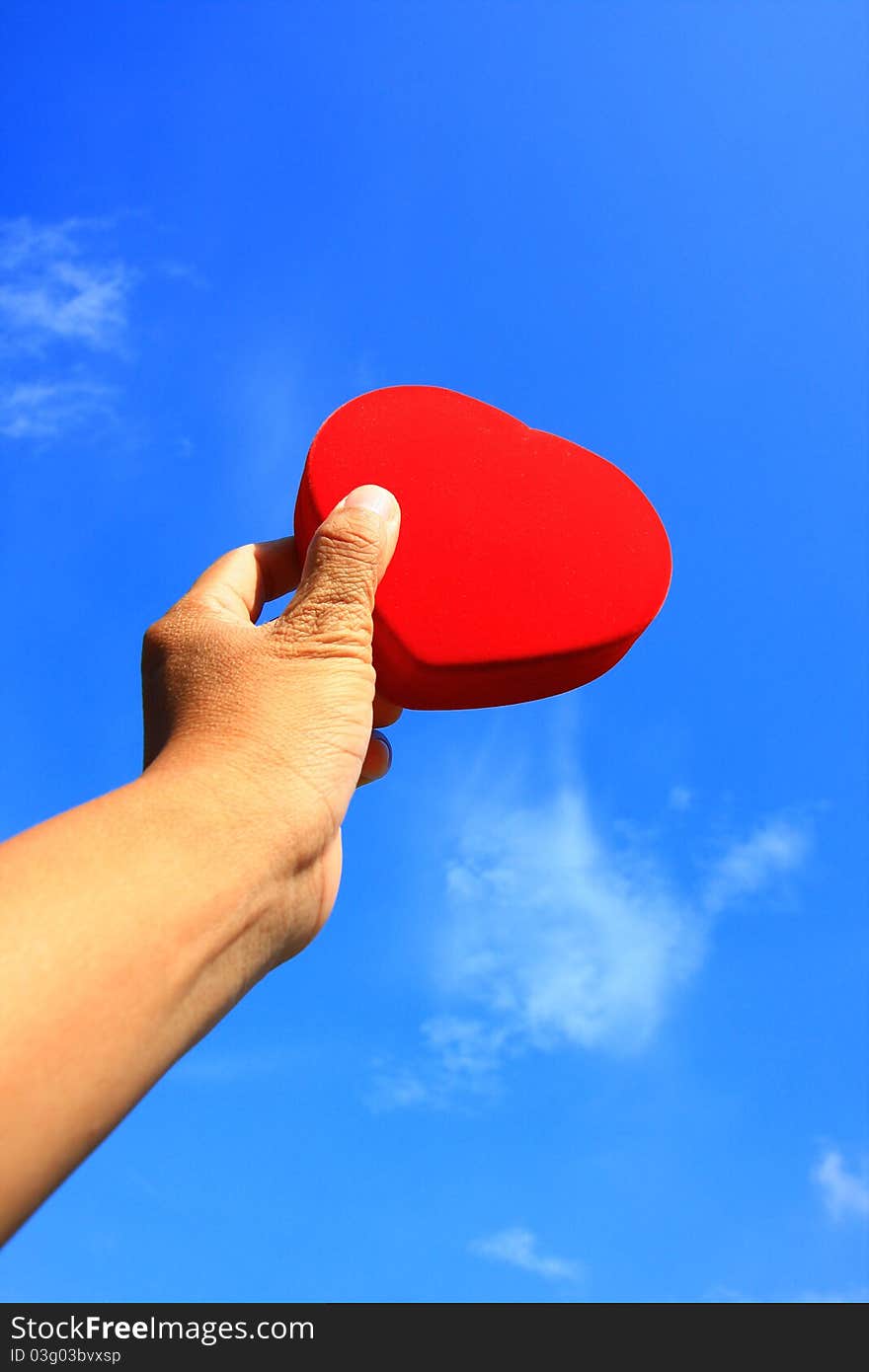 Red heart in hand with blue sky. Red heart in hand with blue sky