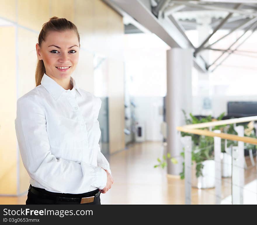 Portrait of a young pretty woman standing inside office building. Portrait of a young pretty woman standing inside office building