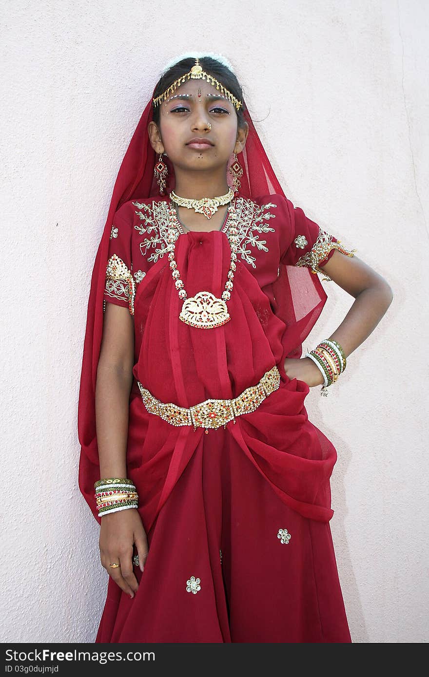 Girl wearing ornaments on head, neck, waist and hand in red dance costume. Girl wearing ornaments on head, neck, waist and hand in red dance costume