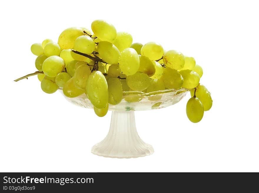 Grapes in a glass vase on the white isolated background